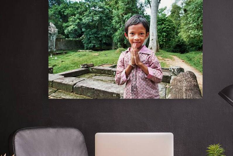 Smiling child offers traditional greeting at ancient temple ruin by Marco Brivio