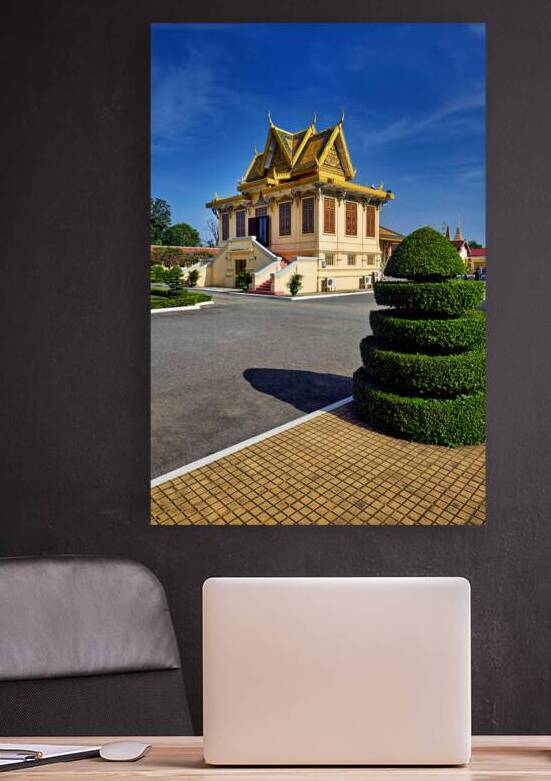 Golden roofed Cambodian building manicured bush and blue sky. by Marco Brivio