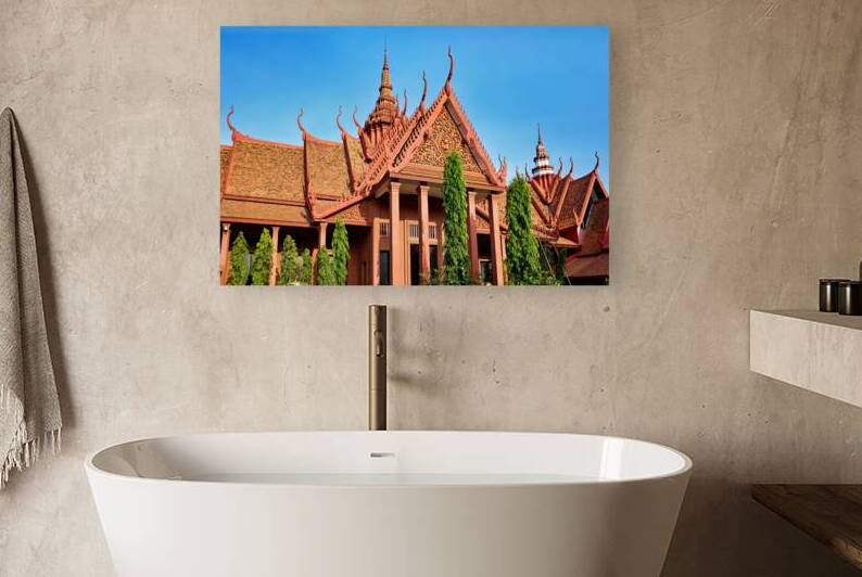 Red roofed Cambodian temple with ornate details against blue sky by Marco Brivio