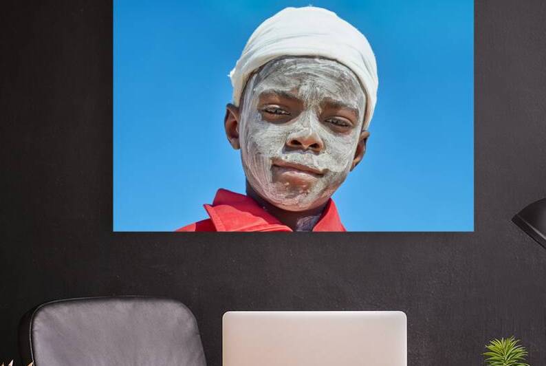 Sad child with a painted face in a village in Damaraland Namibi by Marco Brivio
