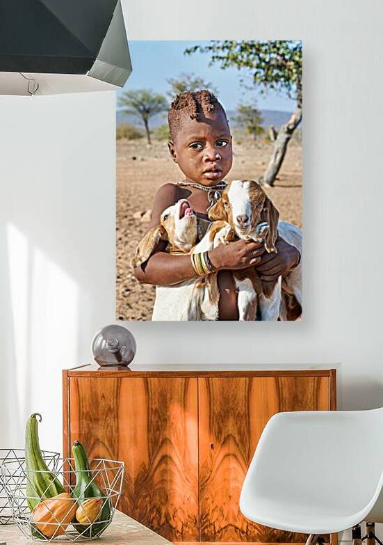 Child carries goats in Himba village of Namibia Kunene Region by Marco Brivio