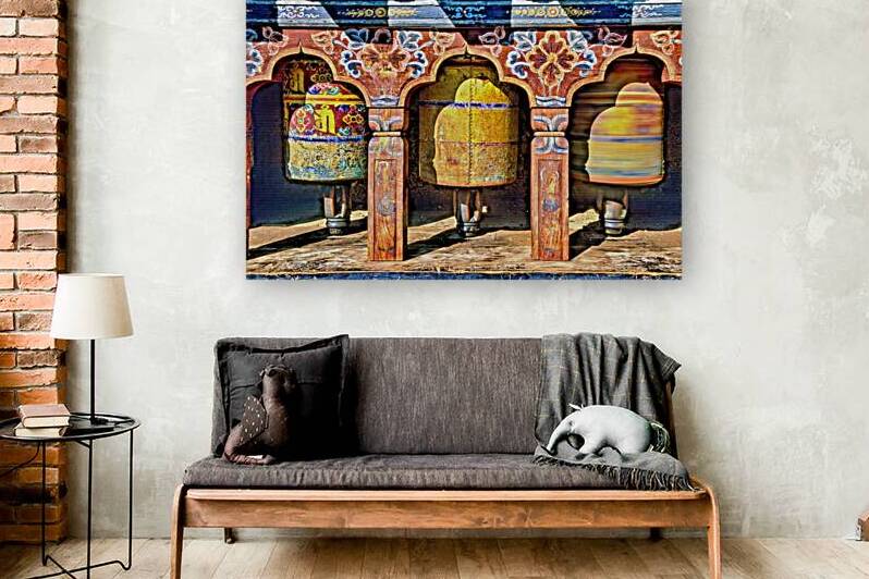 Ornate colorful Buddhist prayer wheels one spinning. by Marco Brivio