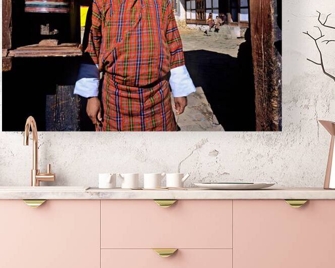 Bhutanese man in traditional gho with prayer wheel. by Marco Brivio