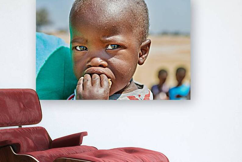 Sad boy in Kavango Region of Namibia looks thoughtful and lost by Marco Brivio