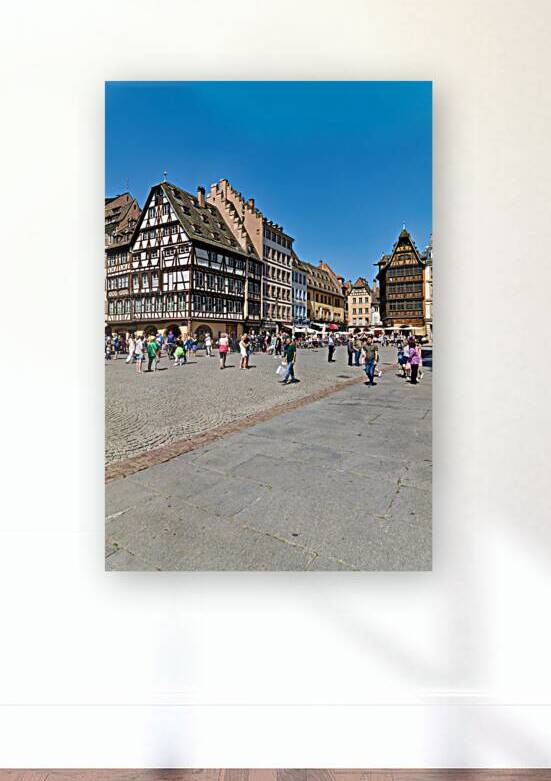 Visitors gather in busy square with colorful houses in Strasbour by Marco Brivio