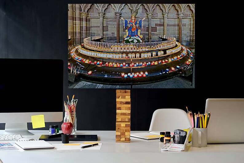 Visitors light votive candles near statue in Strasbourg Cathedra by Marco Brivio