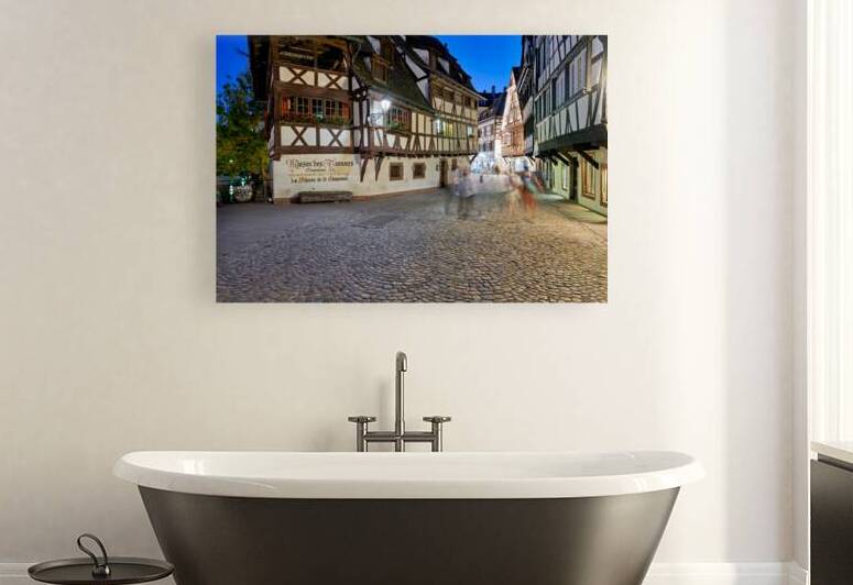 Colorful timber houses and people walking in Strasbourg at night by Marco Brivio