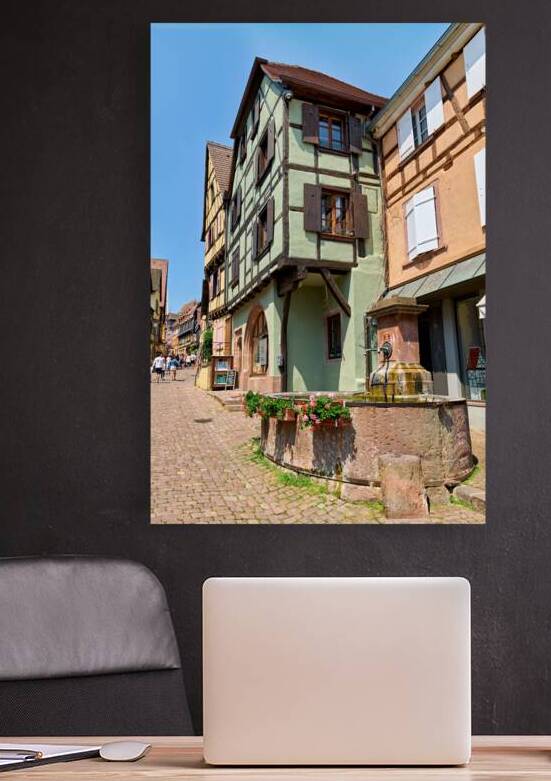 Visitors explore timber framed houses in Riquewihr on a sunny da by Marco Brivio