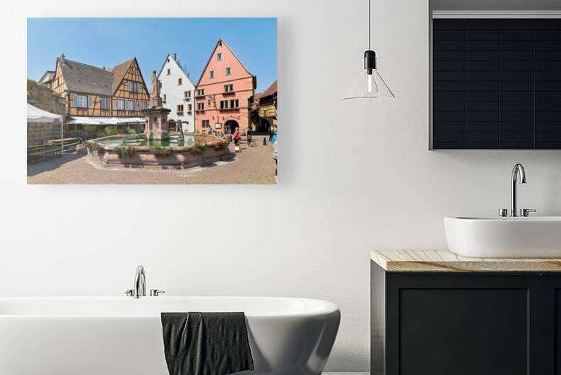 Visitors enjoy Eguisheim square with fountain and historic build by Marco Brivio