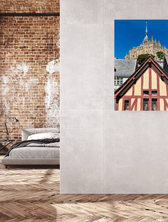 Mont Saint Michel rises above houses in Normandy France on a sun by Marco Brivio