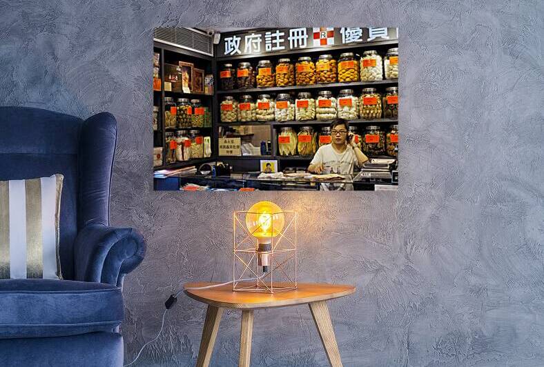 Man talking on phone in traditional herbal shop in Hong Kong by Marco Brivio