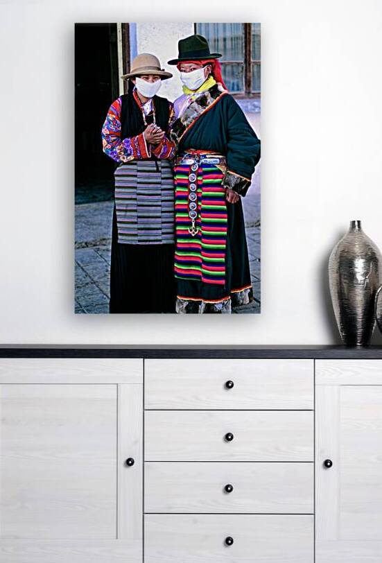 Masked individuals in traditional clothing hold hands in Tibet by Marco Brivio