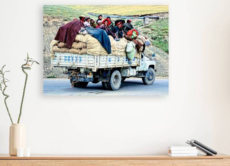 Joyful people riding on a loaded truck in Tibet by Marco Brivio