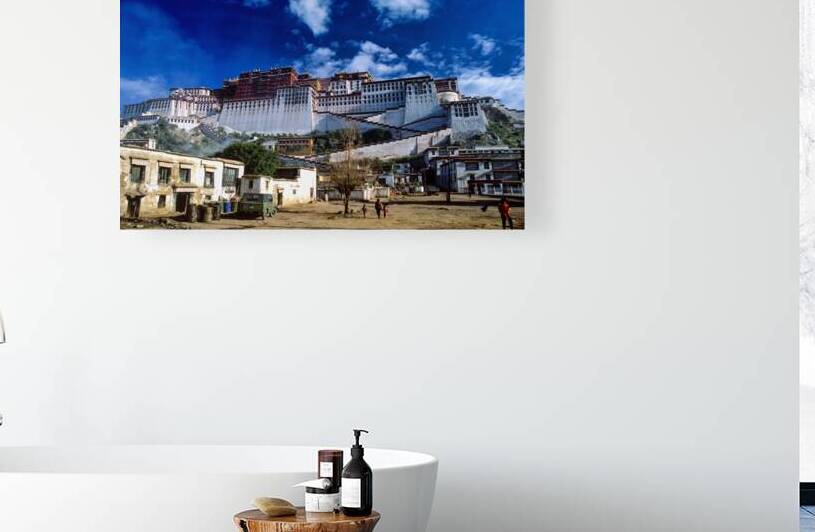 Potala Palace looms over a Tibetan village and blue sky by Marco Brivio