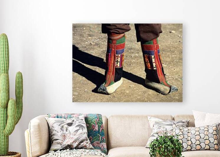 Colorful traditional boots on a person in Tibets landscape by Marco Brivio