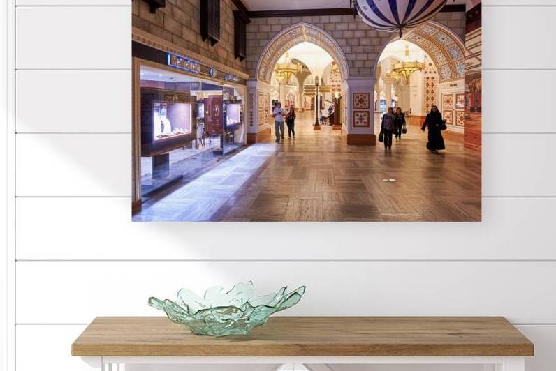 Shoppers explore stores in an Arabian themed mall in Dubai UAE by Marco Brivio