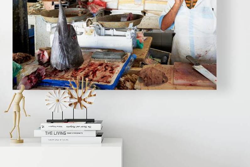 Man talks on phone at busy fish market in Dubai UAE by Marco Brivio