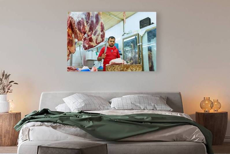 Butcher works with meat in a shop in Dubai UAE by Marco Brivio