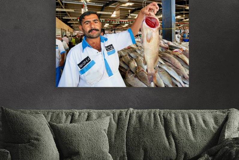 Fishmonger shows fresh catch at market in Dubai during busy day by Marco Brivio