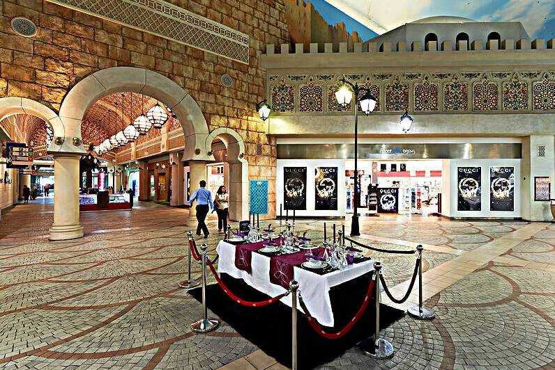 Indoor mall in Dubai features shops and a dining setup with peop by Marco Brivio