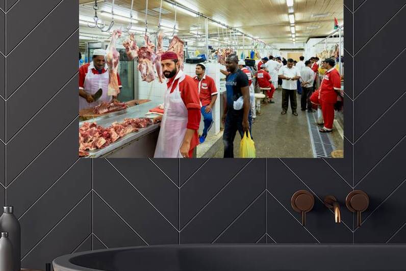 Butchers work at a busy meat market in Dubai UAE preparing fresh by Marco Brivio