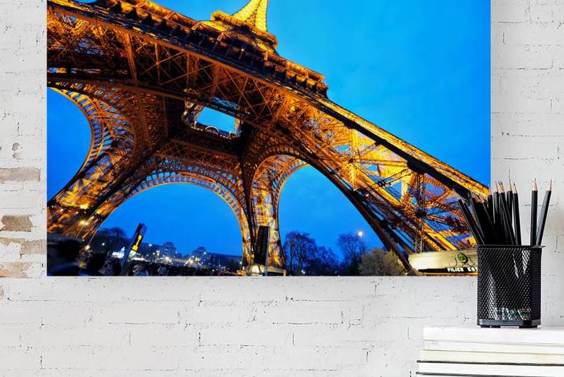 Eiffel Tower stands bright against darkening sky in Paris by Marco Brivio