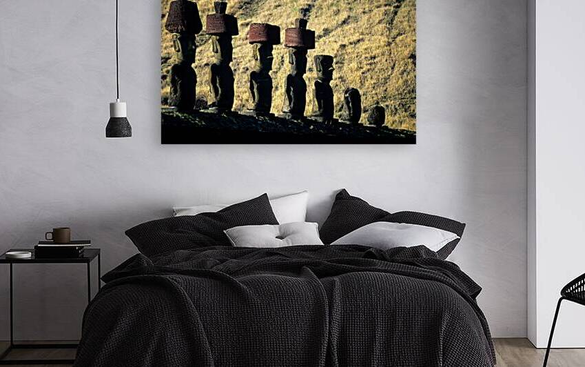 Easter Island Moai statues with red hats on a hillside. by Marco Brivio