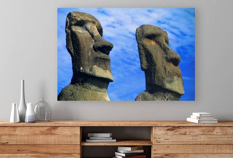 Two Moai statues against a blue sky. by Marco Brivio
