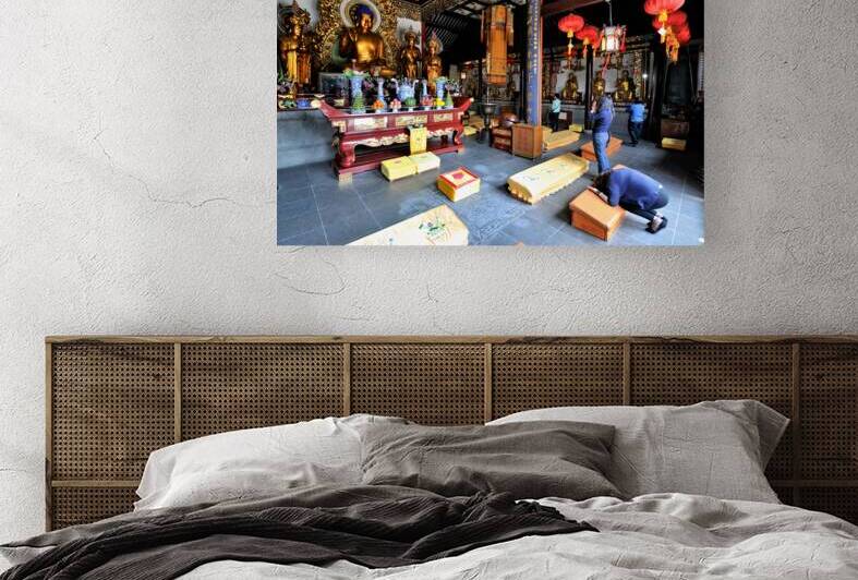 Worshippers offer prayers in a Buddhist temple in Shanghai Chin by Marco Brivio