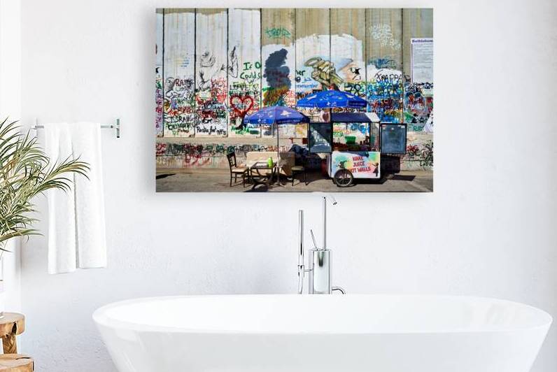 Separation wall in Bethlehem with a juice stand near graffiti by Marco Brivio