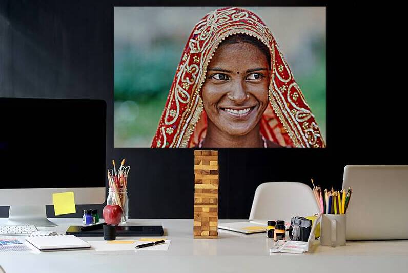 Woman in red traditional dress smiles in Rajasthan by Marco Brivio