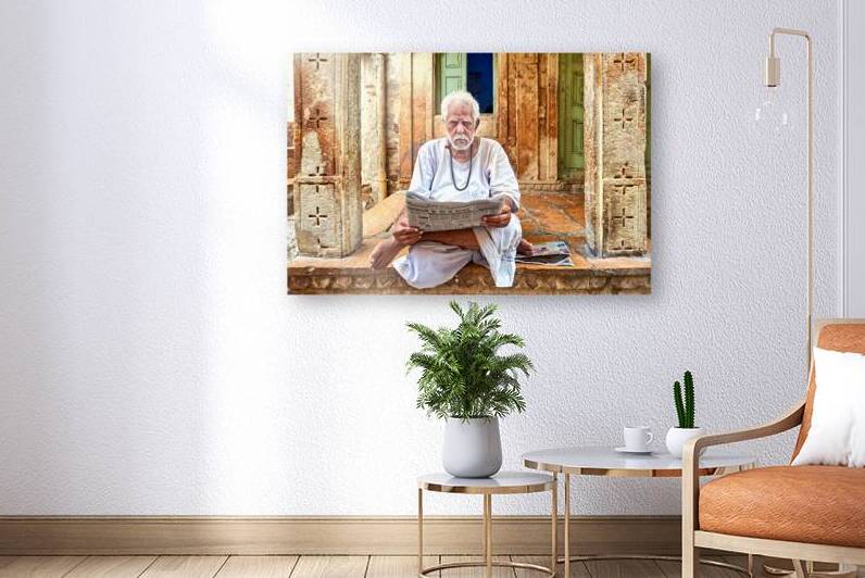 Man reads newspaper on street in Jaisalmer Rajasthan India by Marco Brivio