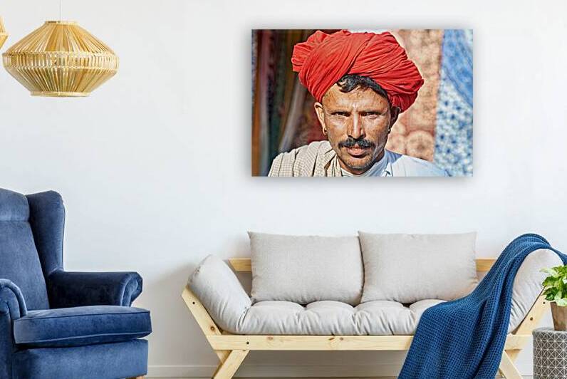 Man in red turban poses in Rajasthans Jaisalmer market street by Marco Brivio
