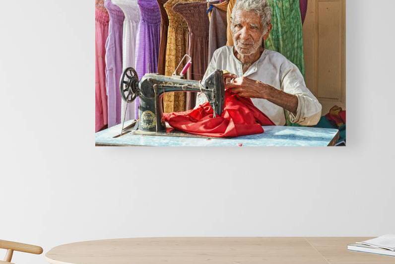 Elder man sewing red fabric in Jaisalmer Rajasthan India by Marco Brivio