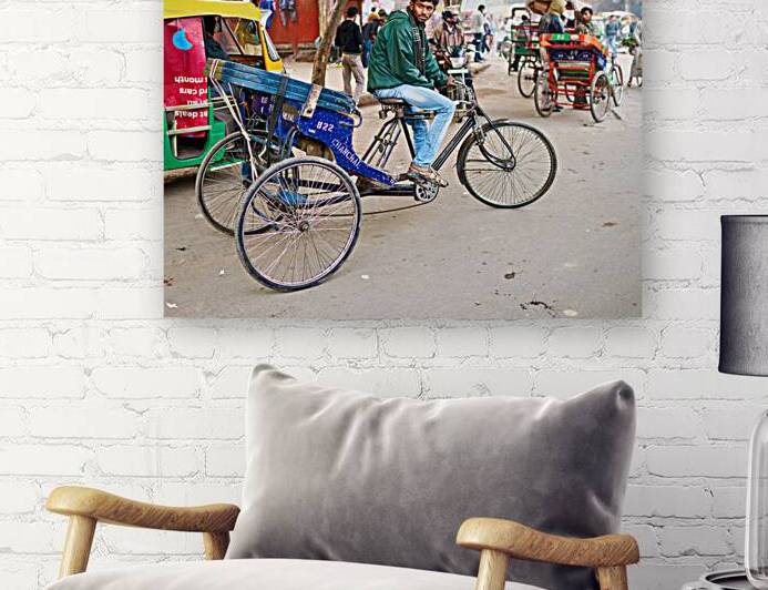 Rickshaw driver resting in Delhis busy street during the day by Marco Brivio