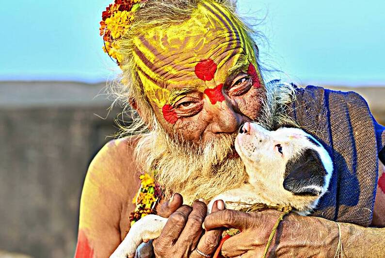 Portrait of a sadhu with a puppy in Orchha Madhya Pradesh Indi by Marco Brivio