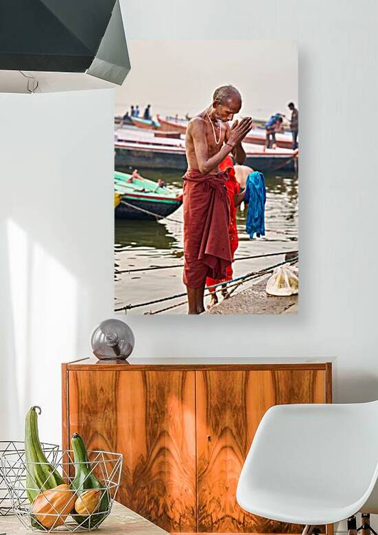 Man praying by the river in Varanasi during early morning hours by Marco Brivio