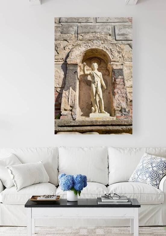 A statue stands in a niche on an ancient wall in Pompeii by Marco Brivio