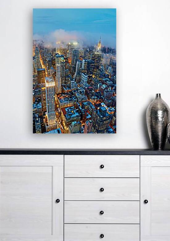 Dusk view of Manhattan showing city lights and skyscrapers by Marco Brivio