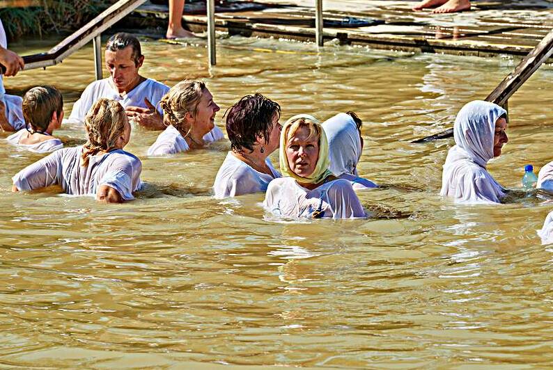 Visitors participate in baptism ceremony at Jordan River site by Marco Brivio