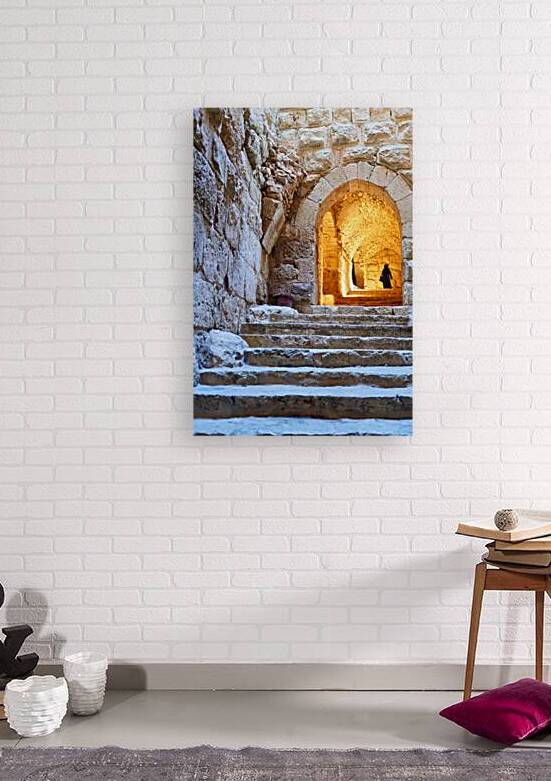 A person walks up stone stairs inside Ajloun castle in Jordan by Marco Brivio