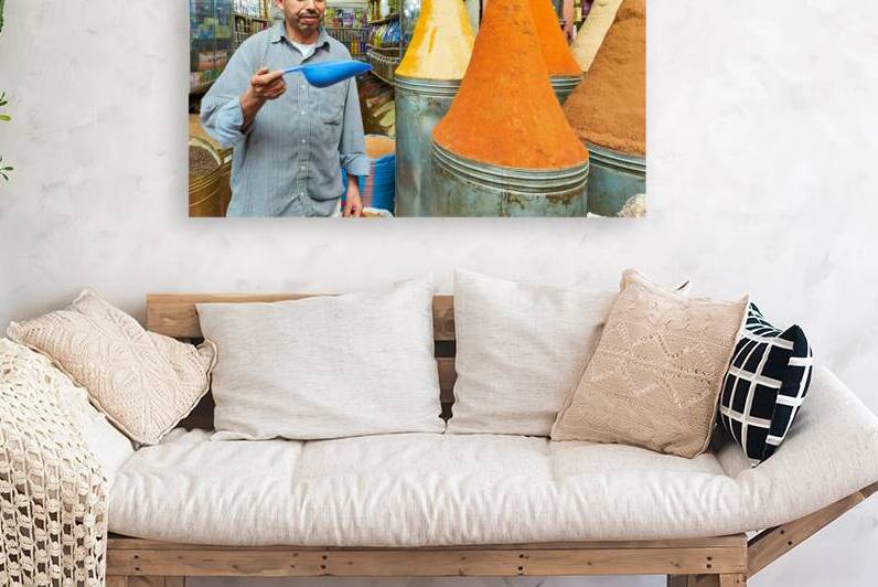 Sale of spices in Marrakesh souk with vendor showing products by Marco Brivio