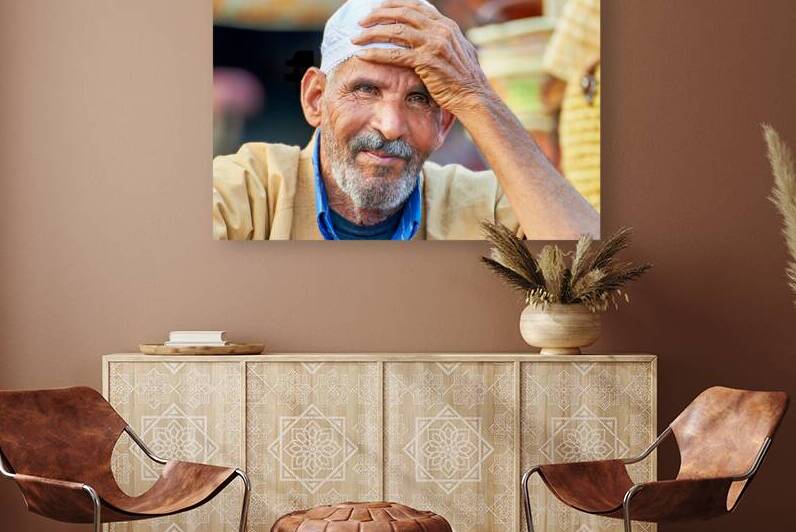 Man smiles at market in Marrakesh Morocco in bright daylight by Marco Brivio