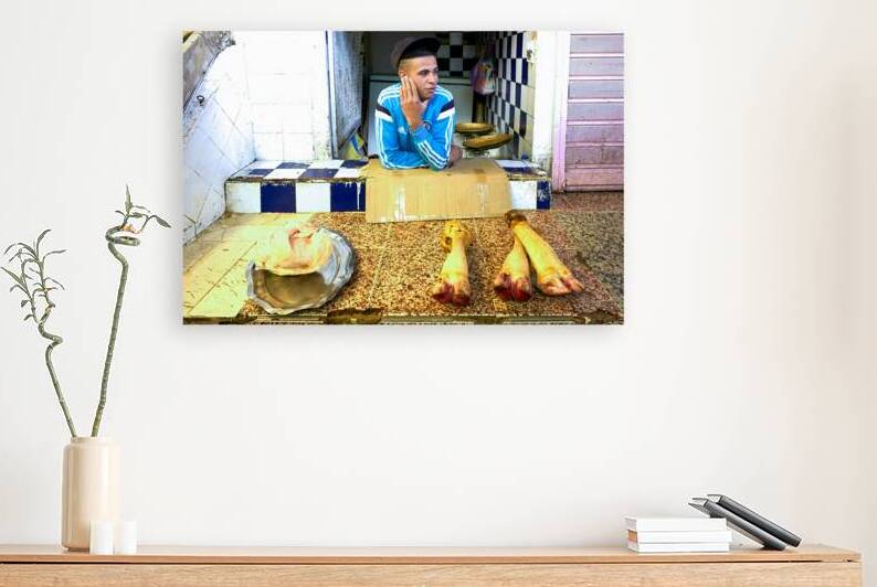 Butcher in Meknes souk interacts with customers during market ho by Marco Brivio