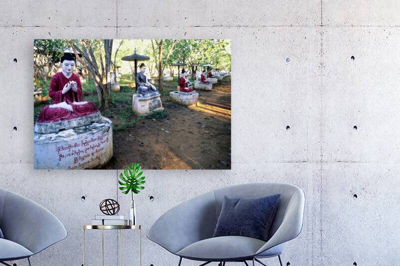 Sacred Buddha statues in Myanmar among trees and sunlight by Marco Brivio