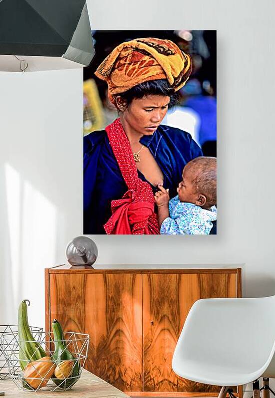 Portrait of a woman feeding her son in Myanmar market place by Marco Brivio