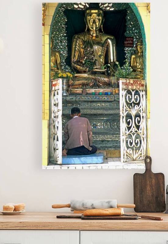 Man prays before a golden Buddha statue in Myanmar chapel by Marco Brivio