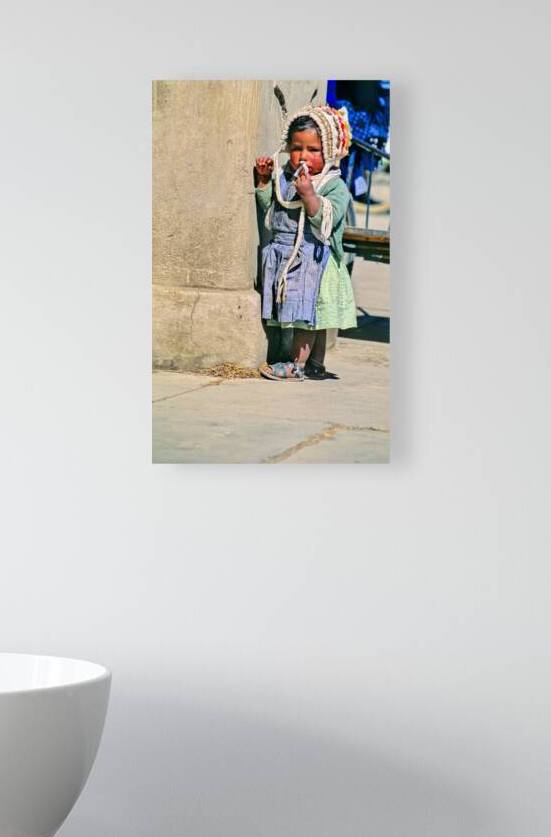 Young child in traditional attire appears to be smoking. by Marco Brivio