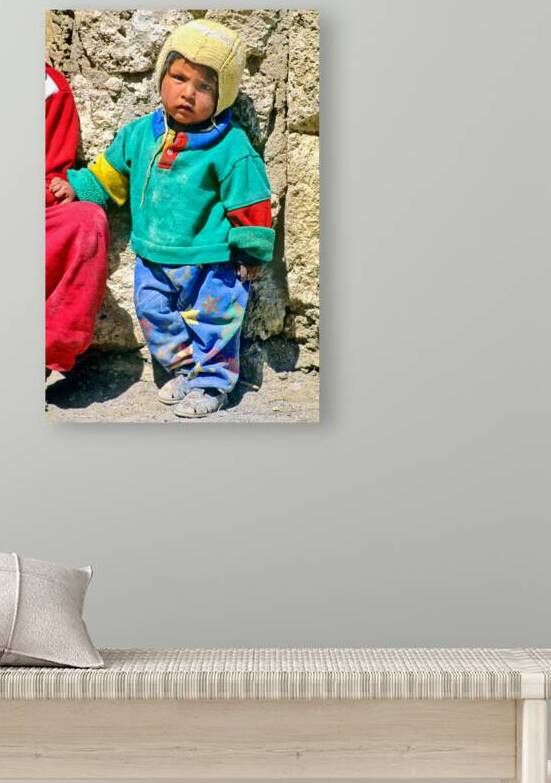 Indigenous child in colorful clothes and yellow hat outdoors. by Marco Brivio