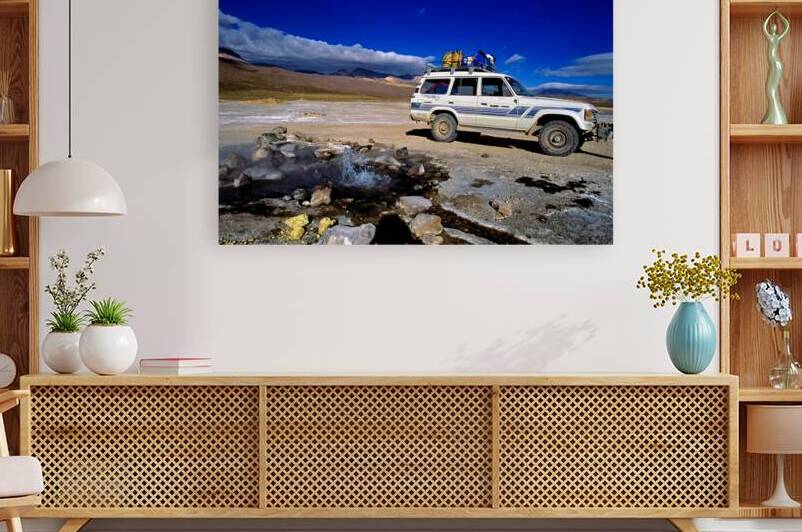 Off road vehicle by geyser in arid mountainous terrain. by Marco Brivio